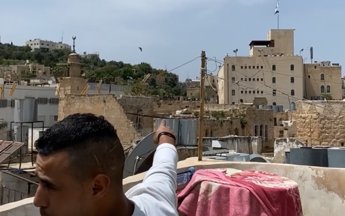 Palästinänser in Hebron zeigt uns von seiner Dachterasse aus, von Israelis, besetzte Häuser (Foto: EMS/Feick)