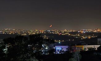 Ausblick von der Dachterrasse des TSS-Internats auf Amman bei Nacht mit orangenem Sichelmond (Foto: EMS/Taut)